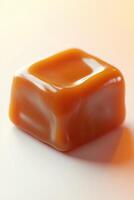 Close-up of a shiny caramel square candy on a white background photo