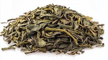 Dry green tea leaves piled in a heap on white background photo