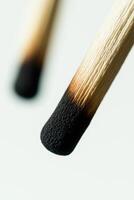 Close-up of matchstick tips with burnt ends against a soft blurred background photo