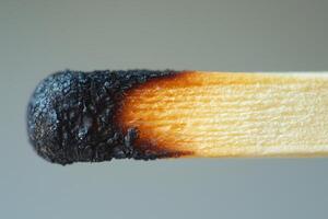 Close-up of a burnt matchstick with charred head and wooden stick highlighting combustion photo
