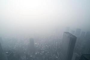 Foggy cityscape view over dense skyscrapers in urban environment photo