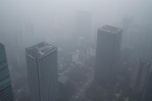 Foggy cityscape over towering skyscrapers in dense mist and fog photo