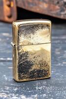 Vintage brass zippo lighter with distressed finish on textured surface photo