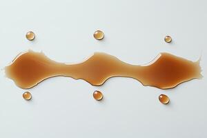 Liquid caramel spill with droplets on a white background photo