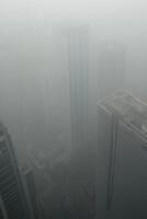 Foggy cityscape with skyscrapers shrouded in dense fog and limited visibility photo