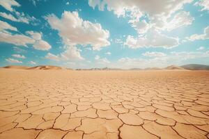 Vast cracked desert landscape under a blue sky with dramatic clouds photo