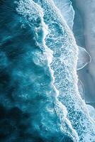 Aerial view of waves crashing onto a sandy beach with turquoise ocean water photo