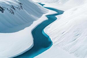 Winding turquoise river flows through pristine snow-covered mountains in winter landscape photo