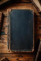 Vintage worn leather-bound book with blank cover on rustic wooden table photo