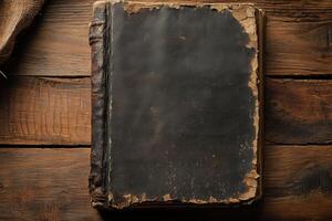 Aged and worn hardcover book with tattered edges on wooden background photo