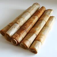 Four rolls of brown paper stacked to resemble cinnamon sticks photo