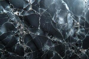 Detailed close-up of black marble with intricate veining and cracks, showcasing a stunning natural stone texture. photo