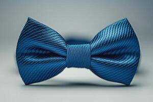 Elegant blue satin bow tie, showcasing a rich texture and sophisticated design against a minimalist backdrop. photo