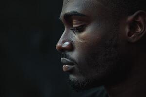 Profile of a thoughtful Black man, showcasing deep contemplation and strong facial features. photo