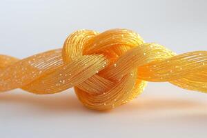 A close-up of an intricate golden knot, showcasing shimmering strands in vibrant yellow hues against a soft background. photo