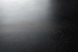 Close-up view of textured black surface with subtle ripples, creating a sophisticated and modern aesthetic. photo