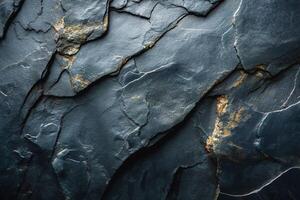 Close-up of textured dark slate rock with golden flecks, showcasing nature's artistry in the rugged surface. photo