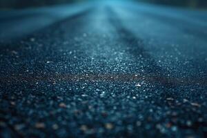 A close-up photo of a wet asphalt road, glistening with moisture under a grayish-blue light.