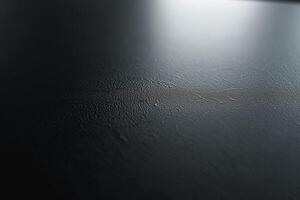 A close-up view of a textured black surface with subtle lines and reflections. photo