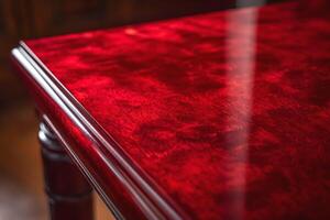 Close-up of a polished red wooden table showcasing intricate grain patterns. photo
