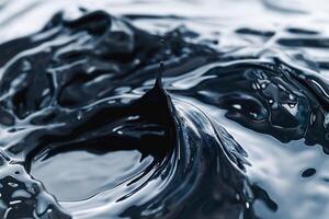 Close-up of swirling black liquid creating an elegant splash, showcasing dynamic movement and texture. photo