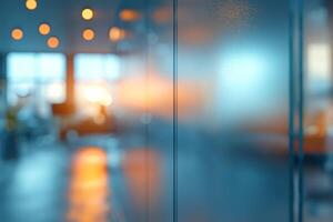 A soft-focus image of a modern office interior with blurred glass partitions reflecting warm, ambient light. photo