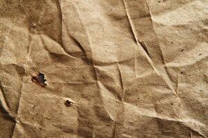 Close-up of a textured, crumpled brown paper showcasing its natural fibers and wear. photo