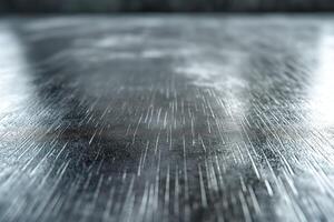Close-up of a textured metal surface with a shiny, reflective quality, showcasing fine scratches and a sleek appearance. photo