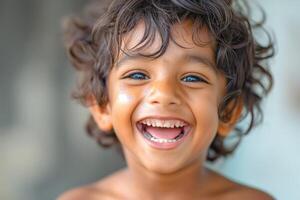 A joyful young boy with curly hair and bright blue eyes smiles widely, radiating happiness. photo