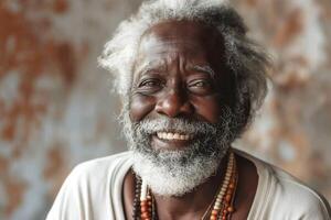 Elderly Black man with a warm smile, adorned in beads, exuding wisdom and joy against a rustic background. photo