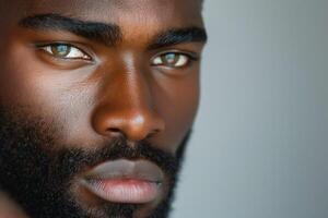 Close-up portrait of a handsome Black man with striking green eyes and a well-groomed beard. photo