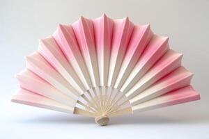 Elegant pink and white folding fan, showcasing intricate design and a smooth gradient, perfect for decor or cultural events. photo
