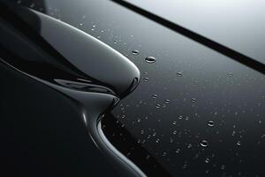 Smooth, glossy black surface with water droplets, emphasizing elegance and fluidity. photo