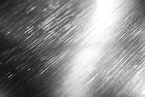 Close-up of brushed metal surface with reflective highlights, showcasing its sleek and modern aesthetic. photo