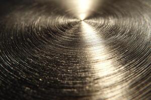 Close-up of a polished metallic surface with concentric circular patterns and reflective light, creating a sleek and modern aesthetic. photo