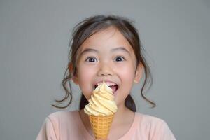 Excited young Asian girl enjoying a sweet cone of ice cream with a joyful expression. photo
