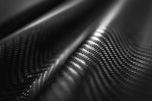 Abstract close-up of textured black carbon fiber material with dynamic patterns and reflections. photo