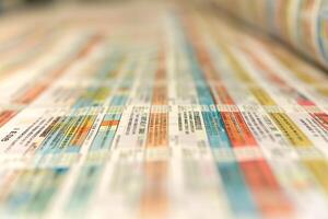 A colorful array of printed materials displaying mixed text and patterns, focusing on vibrant hues and diverse shapes. photo