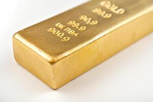 A close-up of a gold bullion bar, showcasing its shimmering surface and engraved details, symbolizing wealth and prosperity. photo