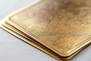 Close-up of a stack of luxurious, textured gold cards showcasing their sheen and elegance. photo