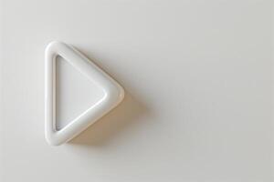 Minimalistic white triangular play button against a soft beige background. photo