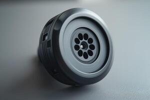 Close-up of a sleek, modern black speaker with a circular grille design, showcasing its intricate detailing and craftsmanship. photo