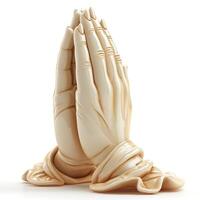 A serene sculpture of praying hands elegantly displayed on a soft draped base. photo