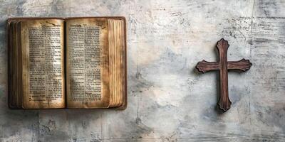 An open vintage book beside a wooden cross, symbolizing faith and spirituality in a serene setting. photo