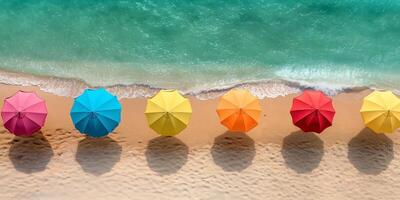 Colorful beach umbrellas lined up on a sandy shore, casting shadows on the beach, creating a vibrant summer scene. photo