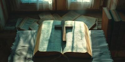An open Bible with a wooden cross resting on it, bathed in soft morning light, creating a serene and reflective atmosphere. photo