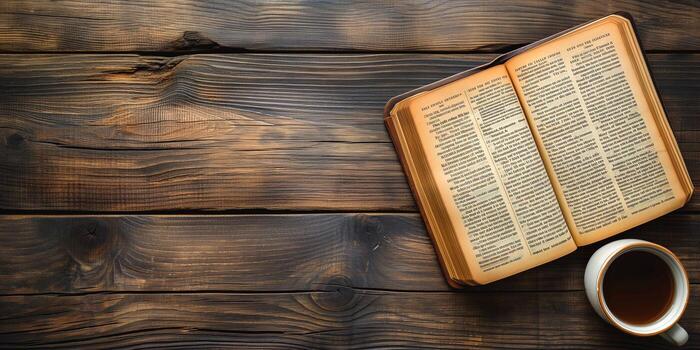 An open book lies on a rustic wooden table next to a steaming cup of coffee. photo