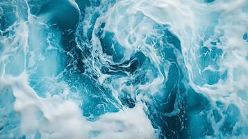 Ocean water swirls and foams in shades of turquoise and white, creating a dynamic, abstract texture of natural beauty. photo