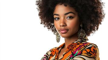 Portrait of a woman with an afro wearing patterned top and unique earrings against a bright white backdrop in a studio setting. photo