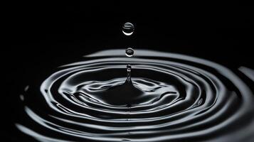 Water droplet falling and causing ripples. Dark background with a focus on the physics, action, and visual impact of a water droplet. photo